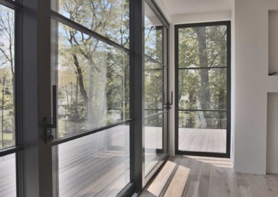 Modern-lift_slide-doors-leading-out-to-a-private-master-bedroom-balcony-with-a-glass-railing